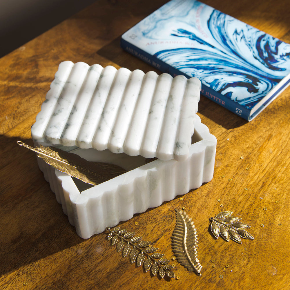 Marble storage box styled on coffee table with décor accents
