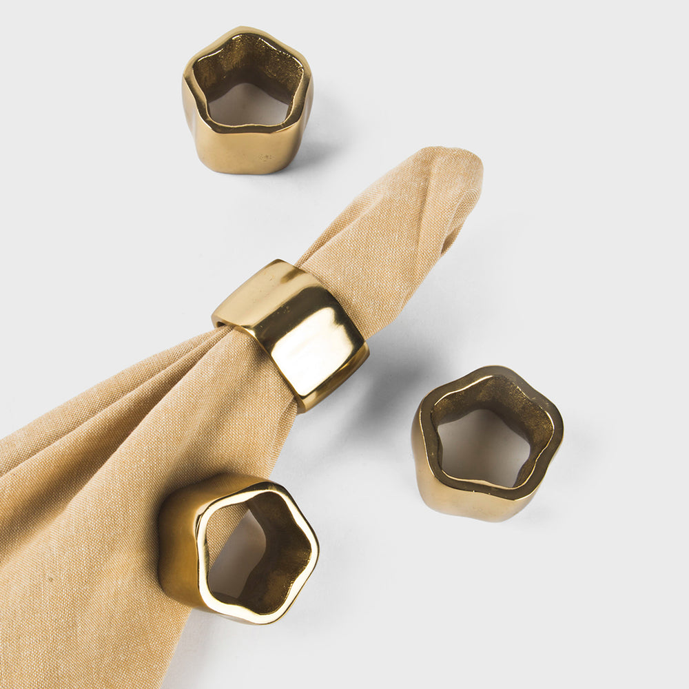 Handcrafted gold metal napkin rings with a polished, textured finish, set of 4