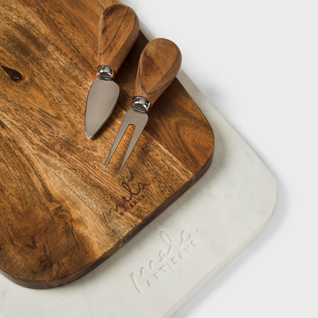 close-up of natural marble veining and acacia wood grain on cutting board set