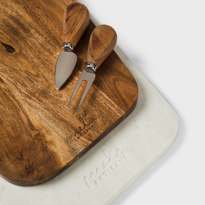 close-up of natural marble veining and acacia wood grain on cutting board set