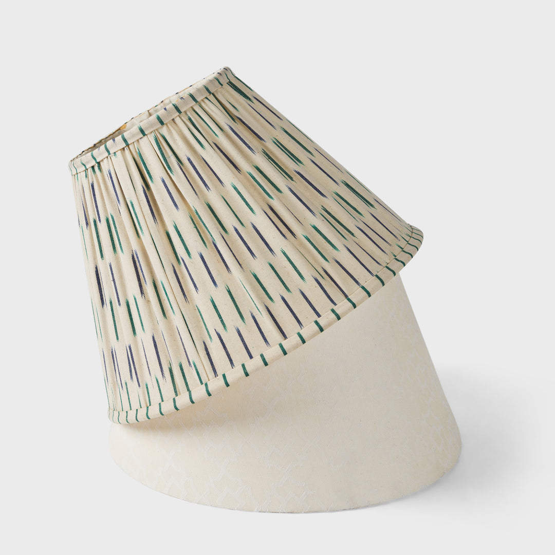 Close-up of a pleated ikat lamp shade with blue and green line detailing.