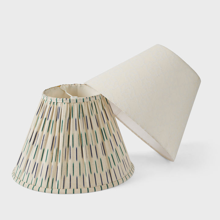 Side-by-side view of the blue ikat pleated shade and the white jacquard textured shade.