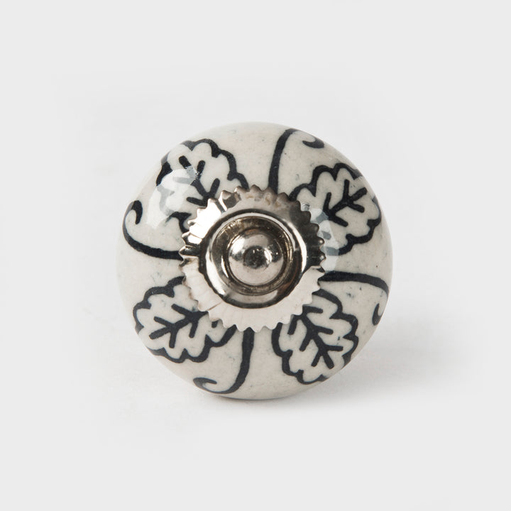 Close-up of hand-painted leafy design and glazed ceramic finish on cabinet knob
