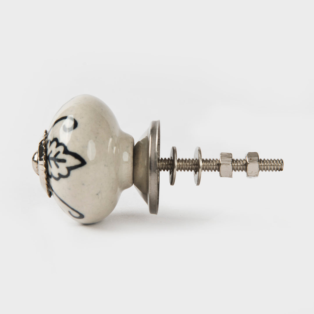 Close-up of hand-painted leafy design and glazed ceramic finish on cabinet knob