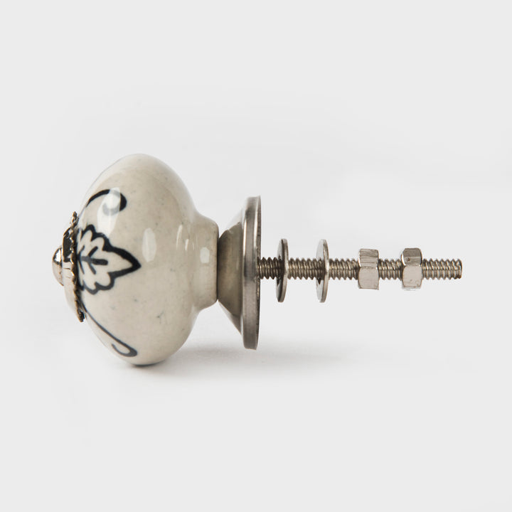 Close-up of hand-painted leafy design and glazed ceramic finish on cabinet knob