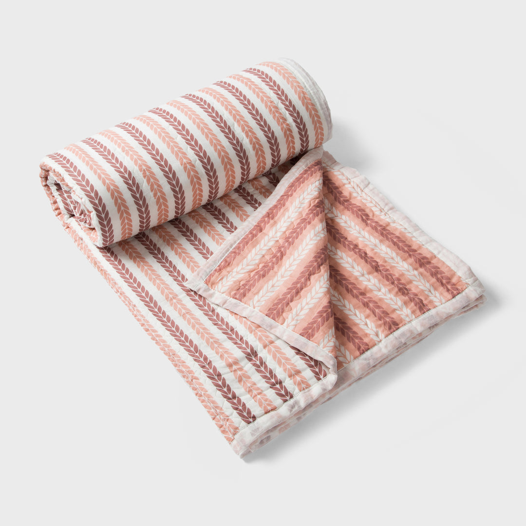 Close-up of cotton fabric texture and leafy stripe pattern on quilt