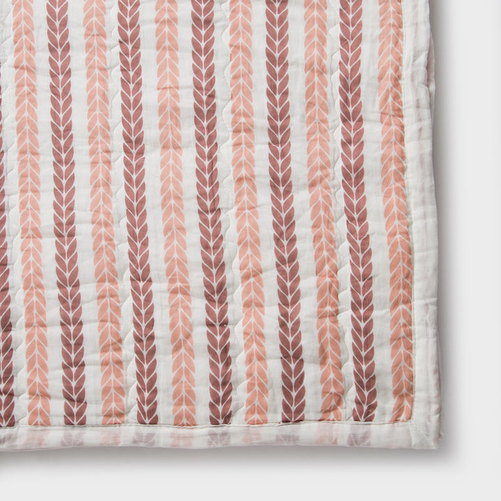 Close-up of cotton fabric texture and leafy stripe pattern on quilt