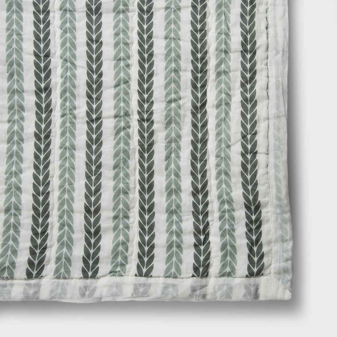 Close-up of cotton fabric texture and leafy stripe pattern on quilt