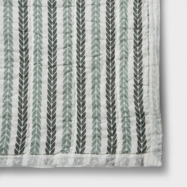Close-up of cotton fabric texture and leafy stripe pattern on quilt