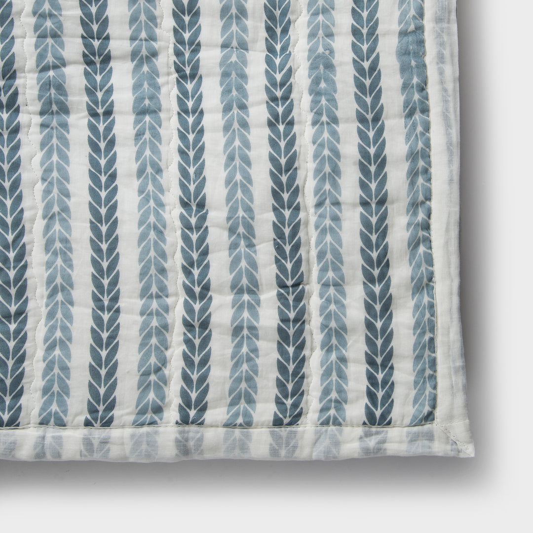 Close-up of cotton fabric texture and leafy stripe pattern on quilt