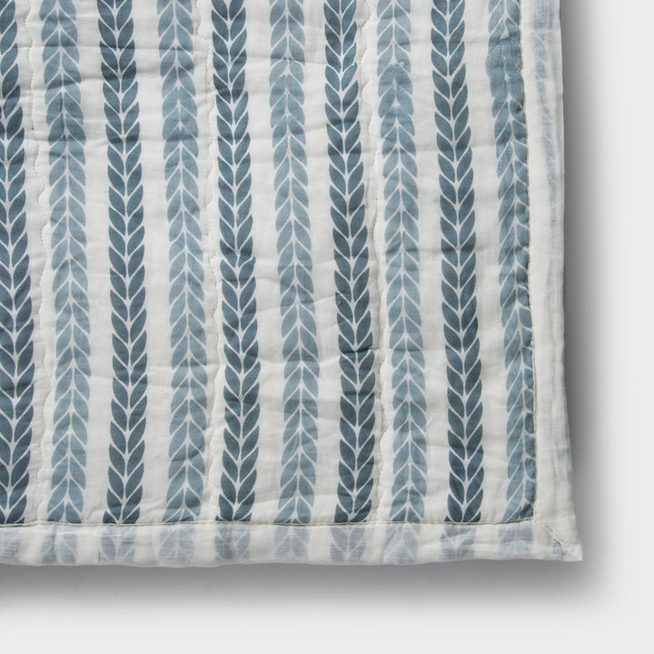 Close-up of cotton fabric texture and leafy stripe pattern on quilt