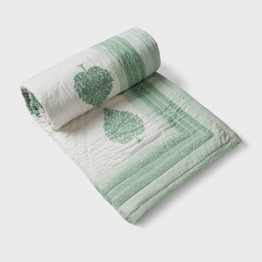 Green floral reversible cotton bed cover in single size displayed on bed