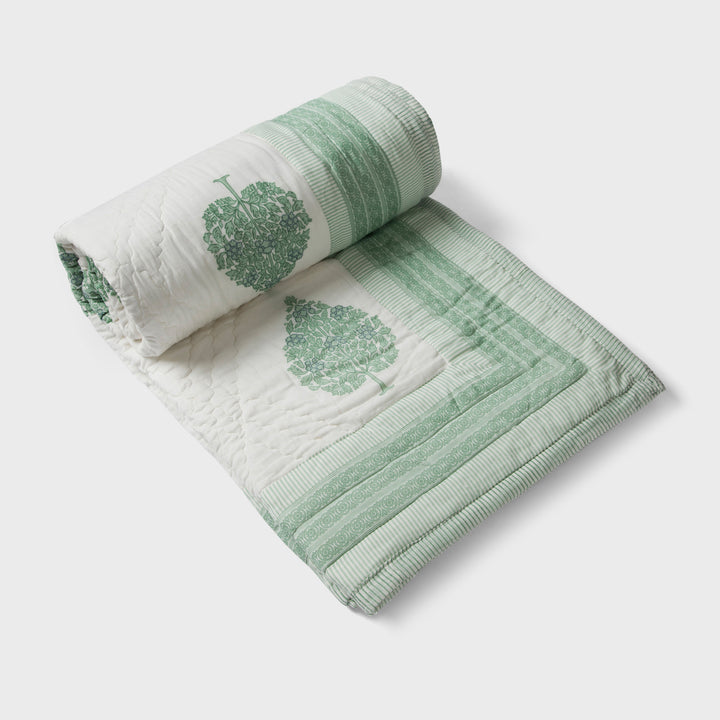Green floral reversible cotton bed cover in single size displayed on bed