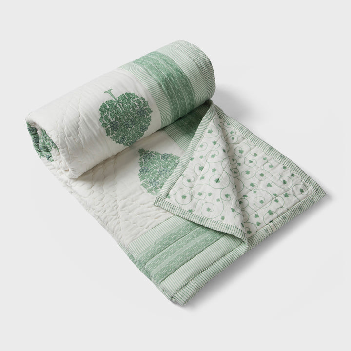 Green floral reversible cotton bed cover in single size displayed on bed
