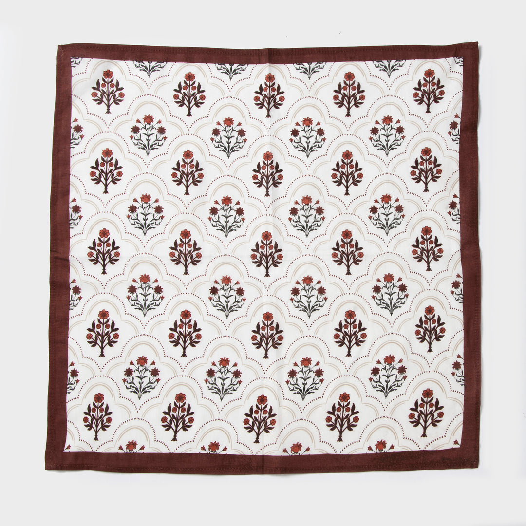Rust and maroon floral printed cotton tablecloth spread on dining table