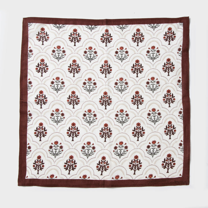 Rust and maroon floral printed cotton tablecloth spread on dining table