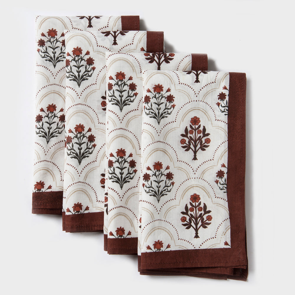 Rust and maroon floral printed cotton tablecloth spread on dining table
