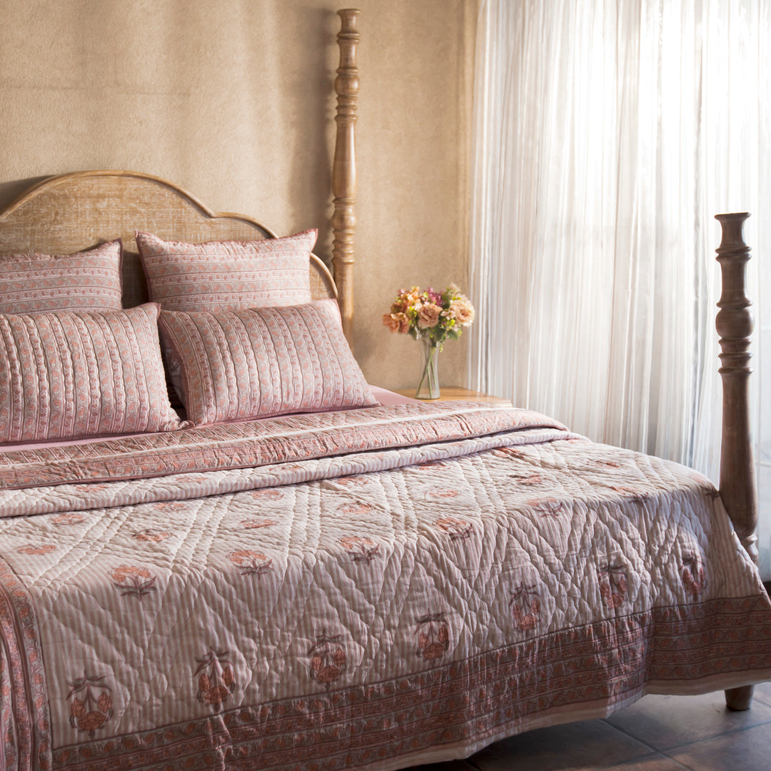 Blush Pink Block printed quilt styled on a bed with coordinated cushions and décor