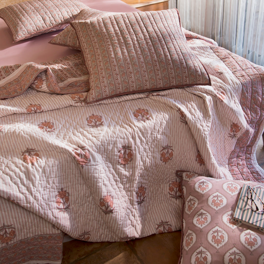 Kunj euro blush pink shams styled on a bed layered with quilt and cushions