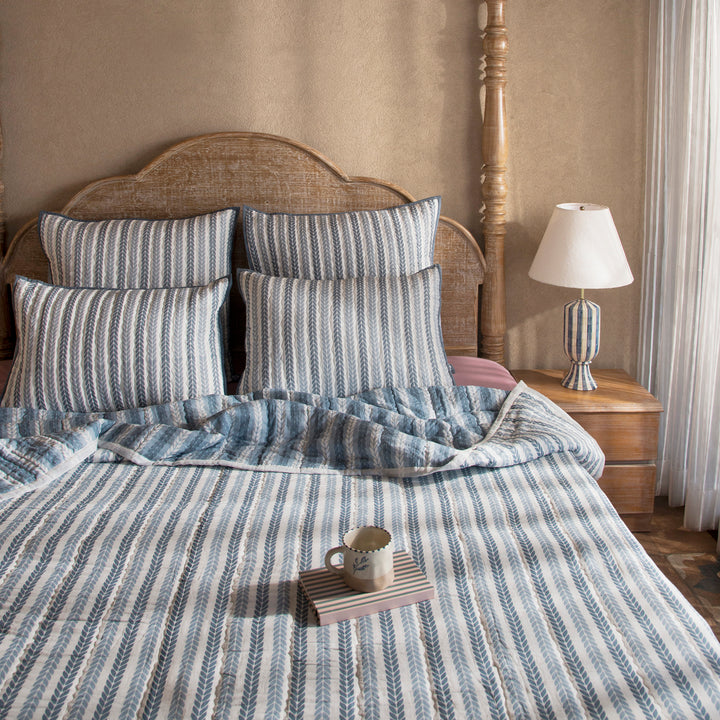 Green leafy stripes reversible cotton quilt in single size displayed on bed
