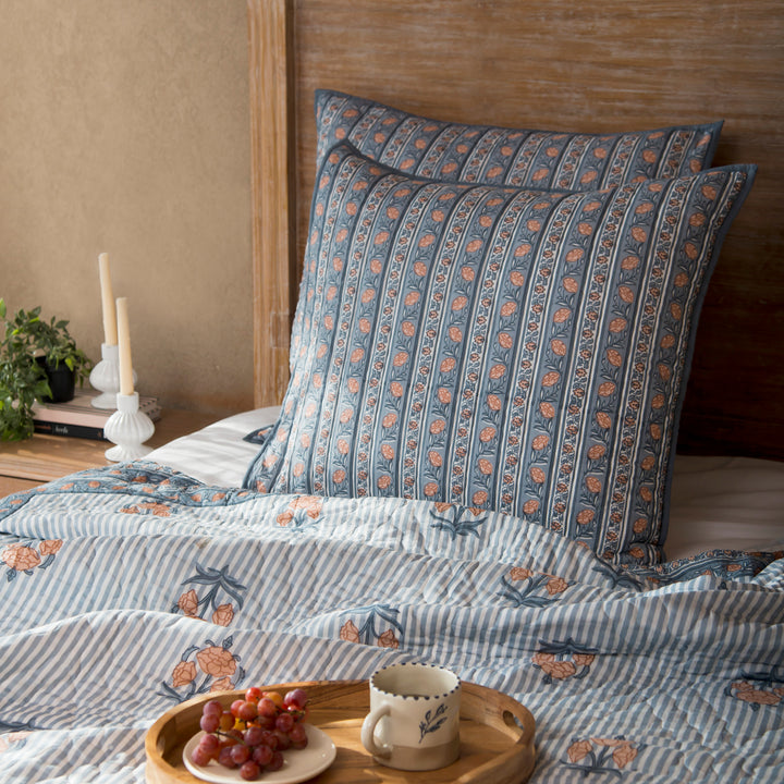 Kunj euro blue shams styled on a bed layered with quilt and cushions