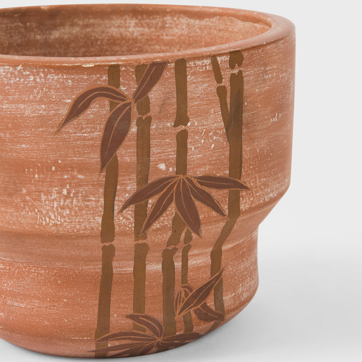  Close-up of raw earthy terracotta texture and hand painted ochre bamboo motif details  