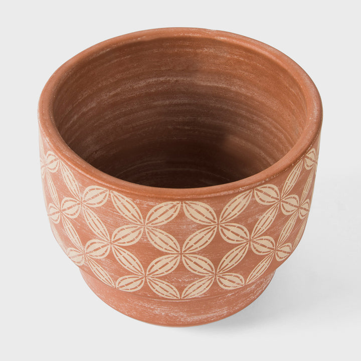 Close-up of stepped profile raw terracotta clay and hand painted cream and ochre band detail  
