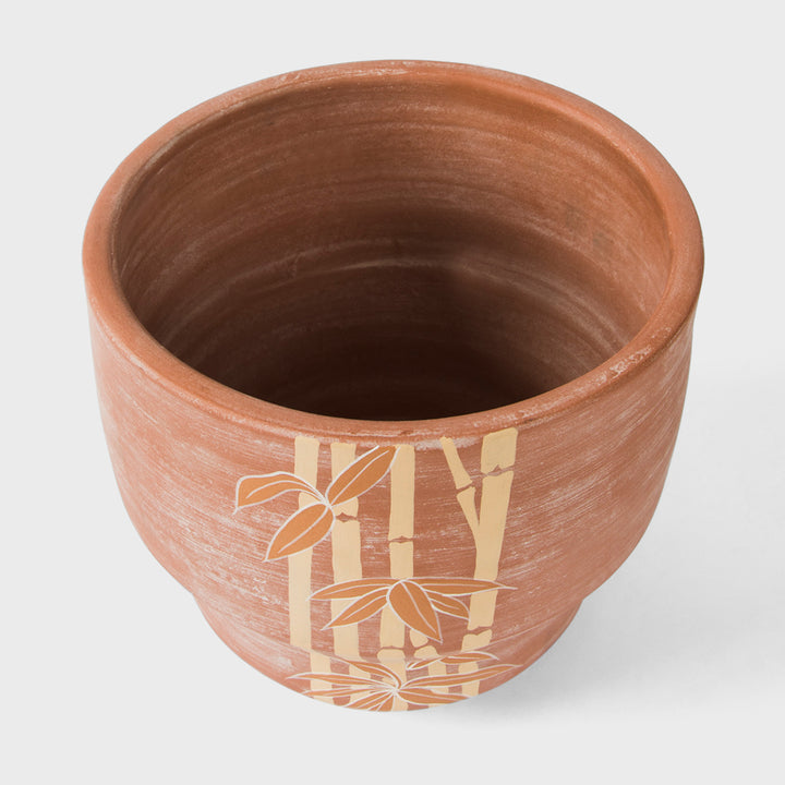 Hand painted bamboo grove terracotta 8.5 diameter planter with ochre and white leaves on a natural clay background  