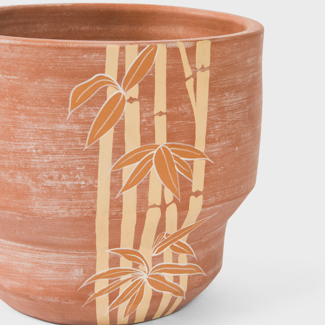  Close-up of raw earthy terracotta texture and hand painted ochre bamboo motif details  