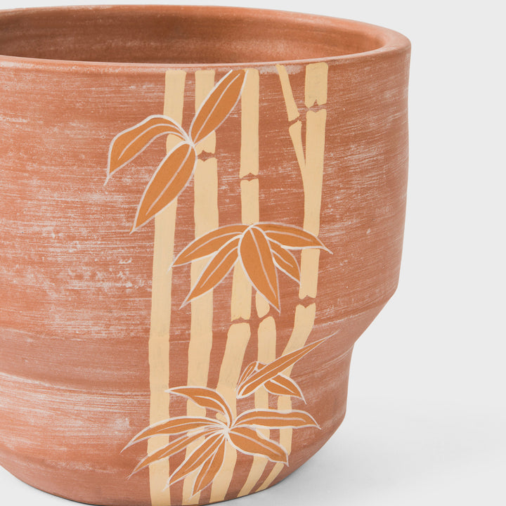 Close-up of raw earthy terracotta texture and hand painted ochre bamboo motif details  