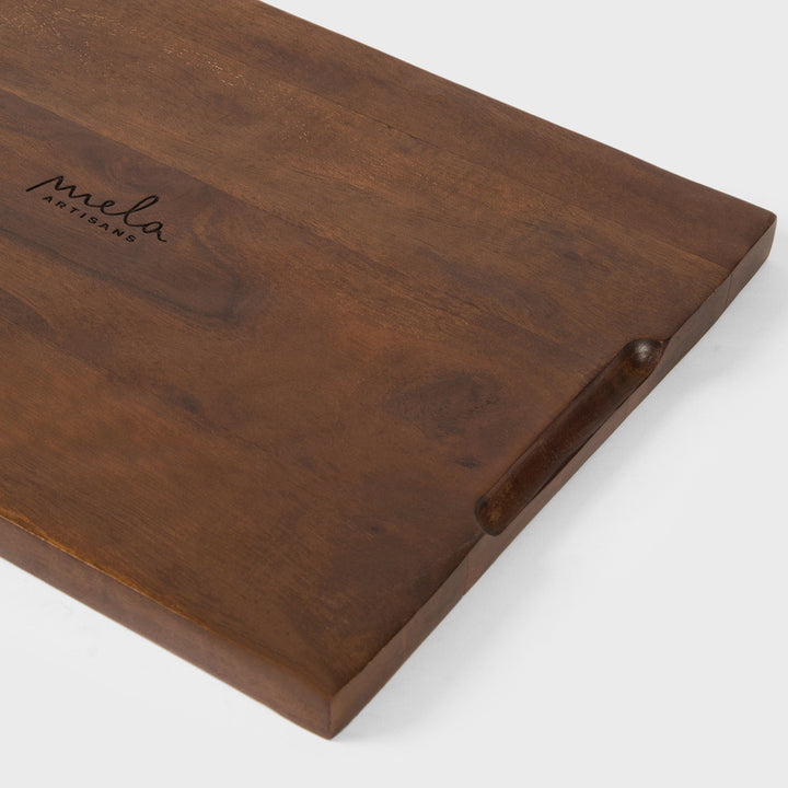 Close-up view of split-edge hand-carved cloud and wave details on dark acacia wood grain