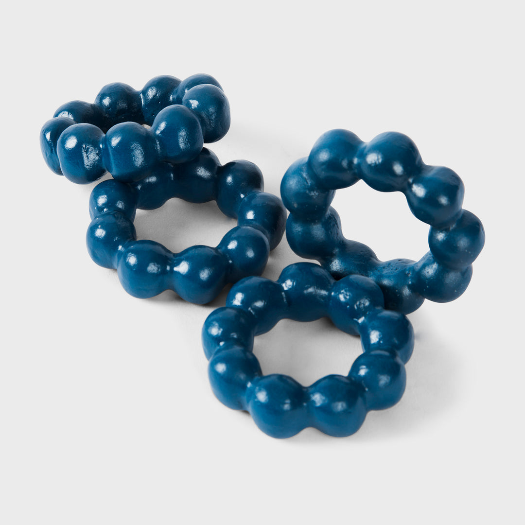 Close-up of the handcrafted terracotta napkin ring showcasing its matte indigo glaze and spherical bubble-beaded design.