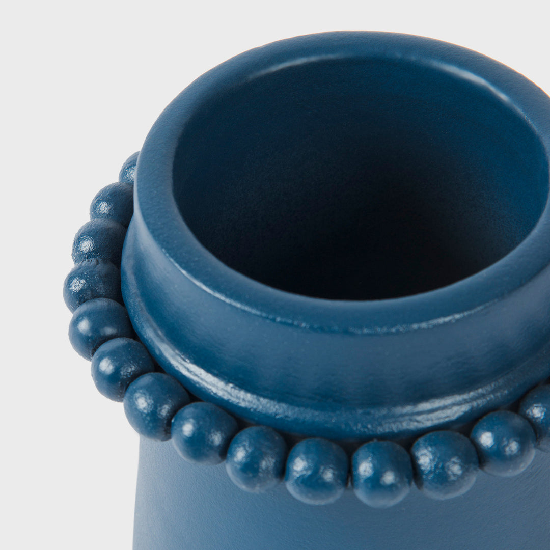 Close-up of the handcrafted terracotta toothbrush holder highlighting the matte indigo glaze and signature raised beaded center band.