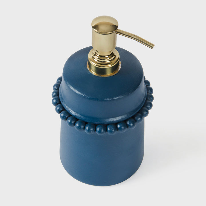 Close-up of the handcrafted terracotta soap dispenser showcasing the matte indigo glaze, raised beaded neck detail, and brushed gold pump.