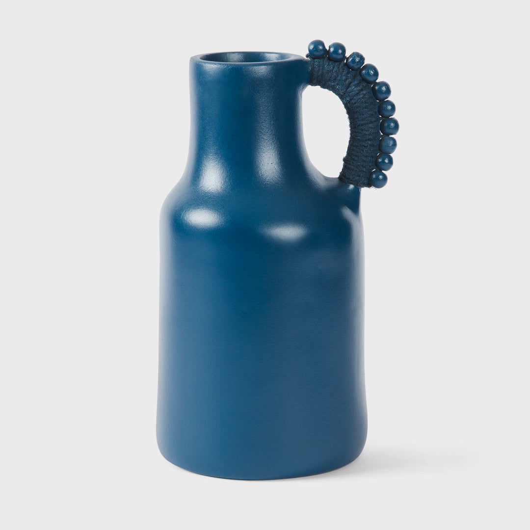 Handcrafted matte indigo terracotta pitcher with a sculptural beaded handle wrapped in tonal cord by Mela Artisans.