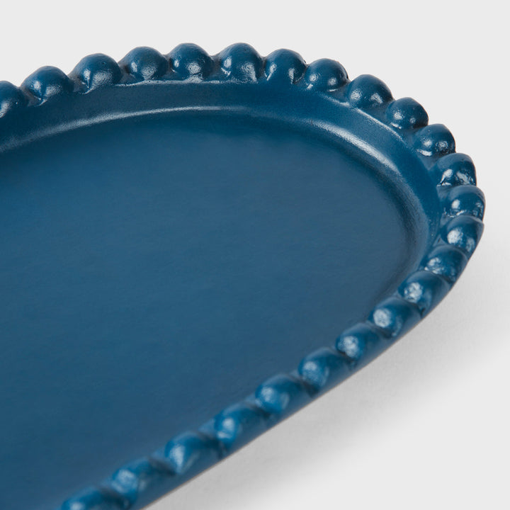 Close-up of the handcrafted terracotta serving platter highlighting the matte indigo glaze and raised beaded border.
