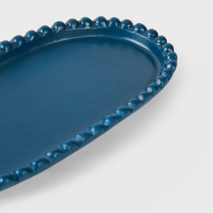 Close-up of the handcrafted terracotta serving platter highlighting the matte indigo glaze and raised beaded border.