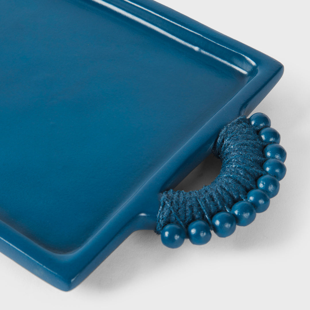 Close-up of the handcrafted terracotta serving tray showcasing its matte indigo glaze, raised rim, and sculptural beaded handles wrapped in tonal cord.