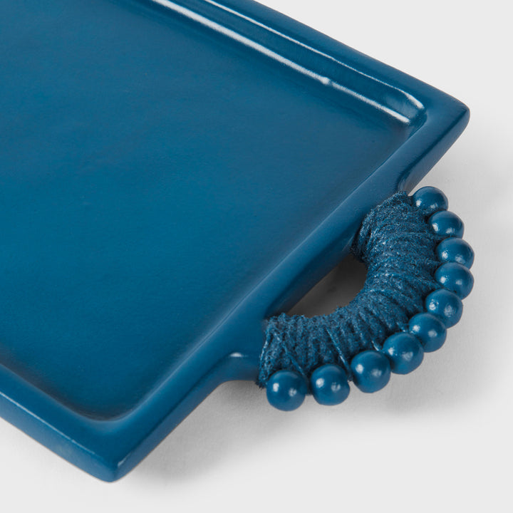 Close-up of the handcrafted terracotta serving tray showcasing its matte indigo glaze, raised rim, and sculptural beaded handles wrapped in tonal cord.