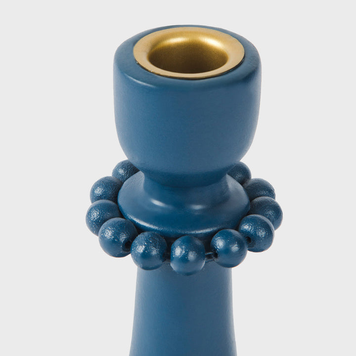 Close-up of the handcrafted terracotta candle holder showcasing the matte indigo glaze, raised bead accents, and sculptural scalloped base.