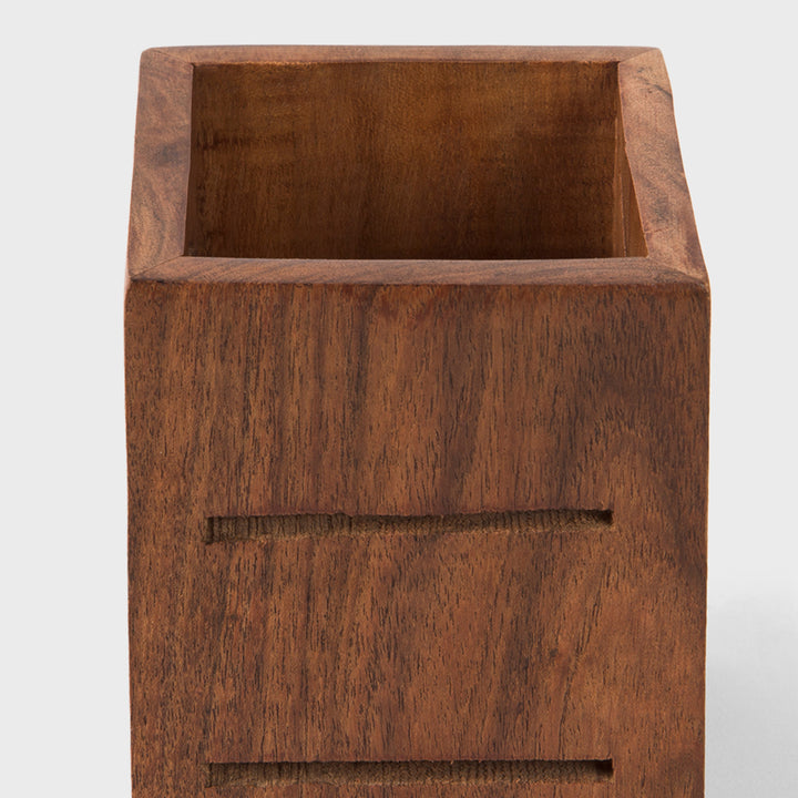 Close-up of smooth natural acacia wood grain texture and geometric carved slots