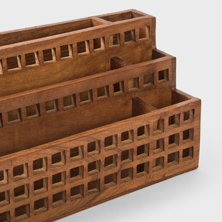 Close-up of grid cutout pattern and natural acacia wood grain texture