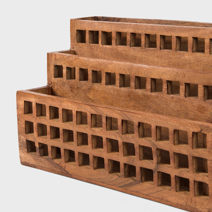 Close-up of grid cutout pattern and natural acacia wood grain texture