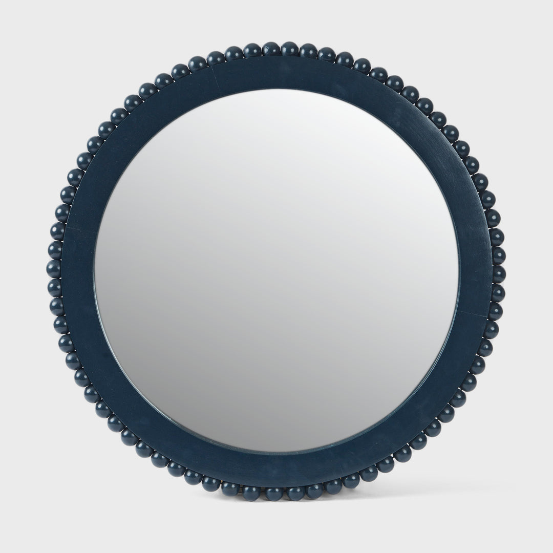 Handcrafted matte indigo round mango wood wall mirror with a hand-carved beaded frame by Mela Artisans.