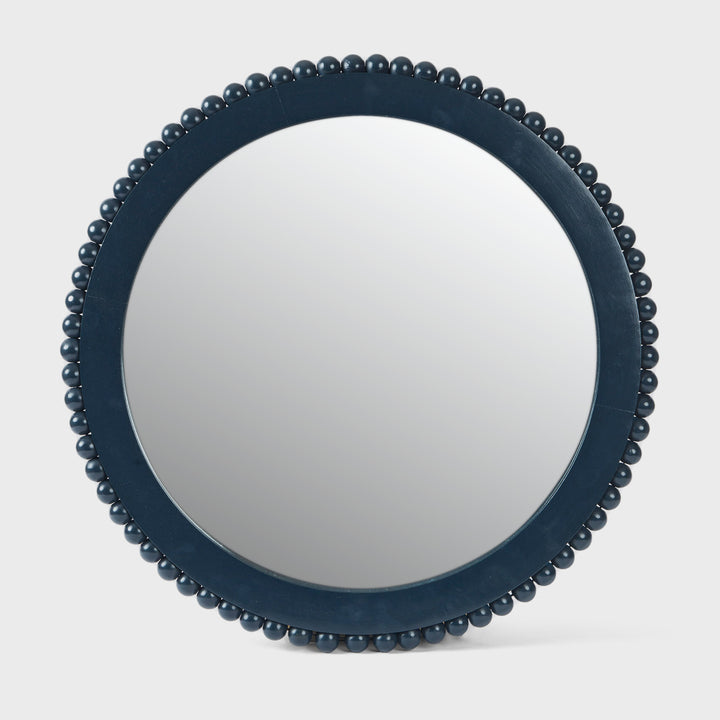 Handcrafted matte indigo round mango wood wall mirror with a hand-carved beaded frame by Mela Artisans.
