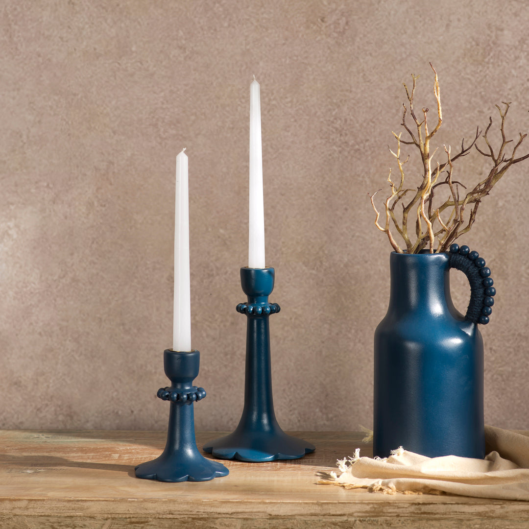 Handcrafted indigo terracotta candle holder styled on a dining table with a lit taper candle creating a warm, elegant ambiance.