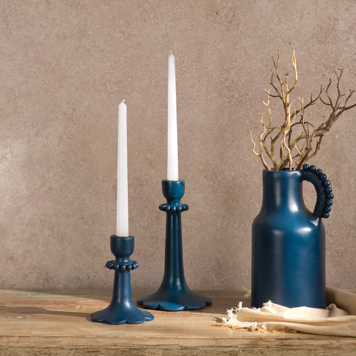 Handcrafted indigo terracotta candle holder styled on a dining table with a lit taper candle creating a warm, elegant ambiance.
