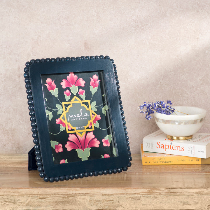 Handcrafted indigo mango wood 8 x 10 photo frame displayed on a console table with a favorite family photograph and coordinating artisan décor.