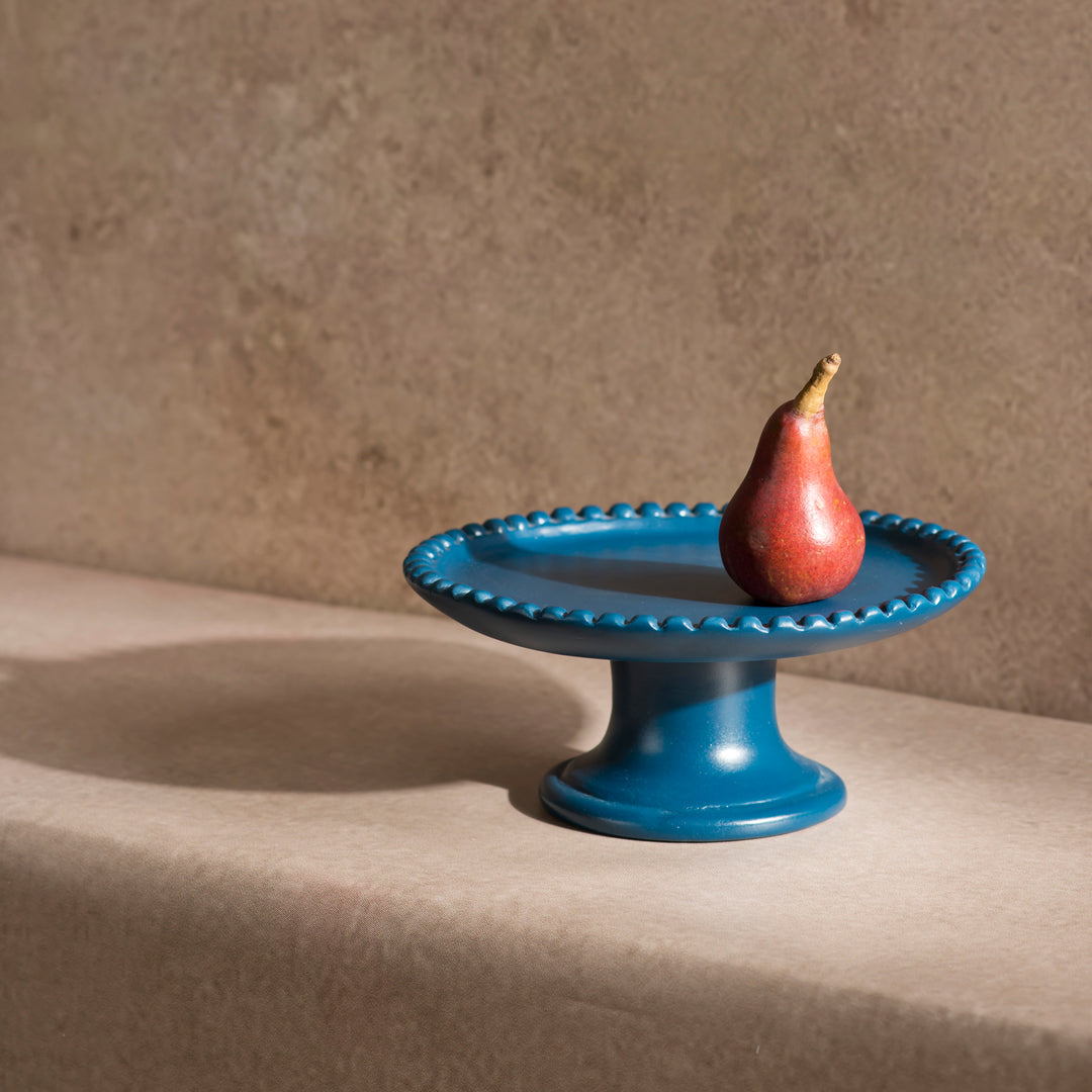 Handcrafted terracotta pedestal cake stand styled with desserts and artisan table décor for an elegant dining presentation.
