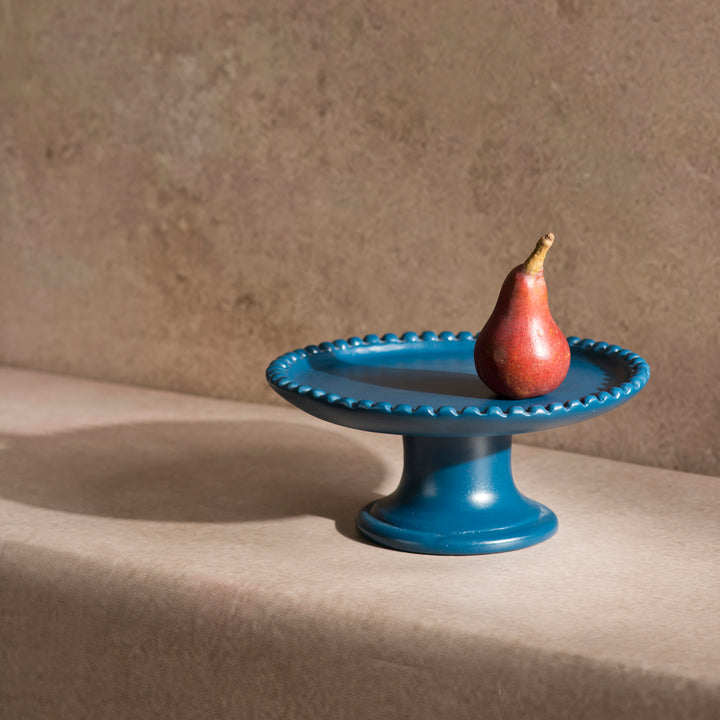 Handcrafted terracotta pedestal cake stand styled with desserts and artisan table décor for an elegant dining presentation.
